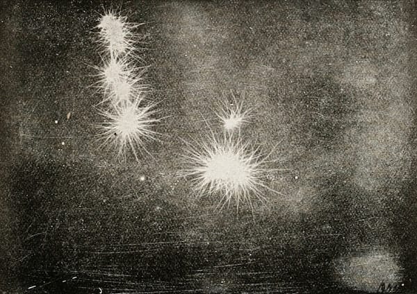 a black scratchy image with several white bursts that look a bit like fireworks