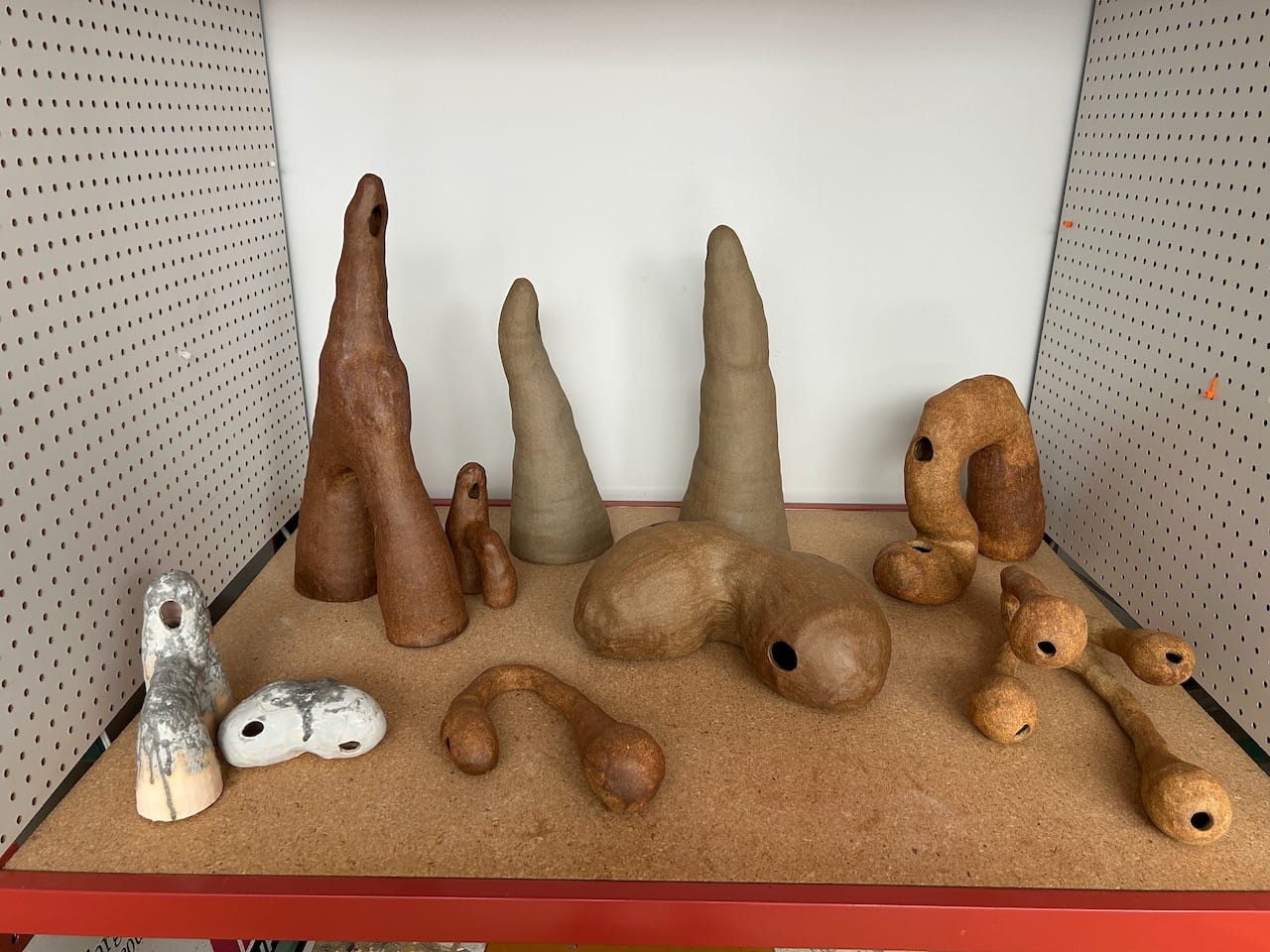 a desk covered in lumpy abstract clay sculptures