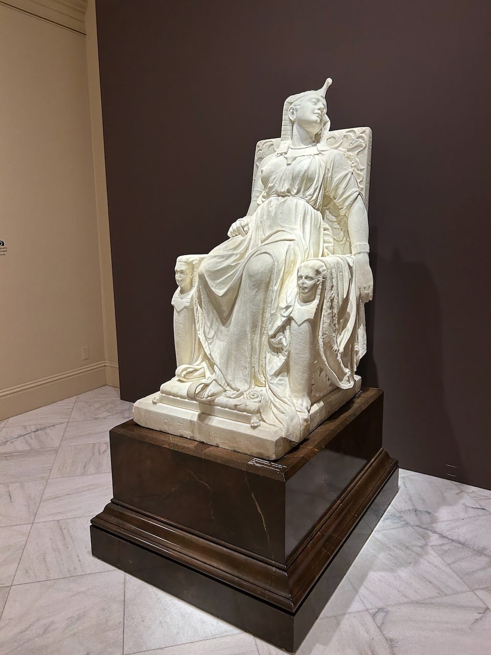 A white marble statue showing Cleopatra dead in her chair