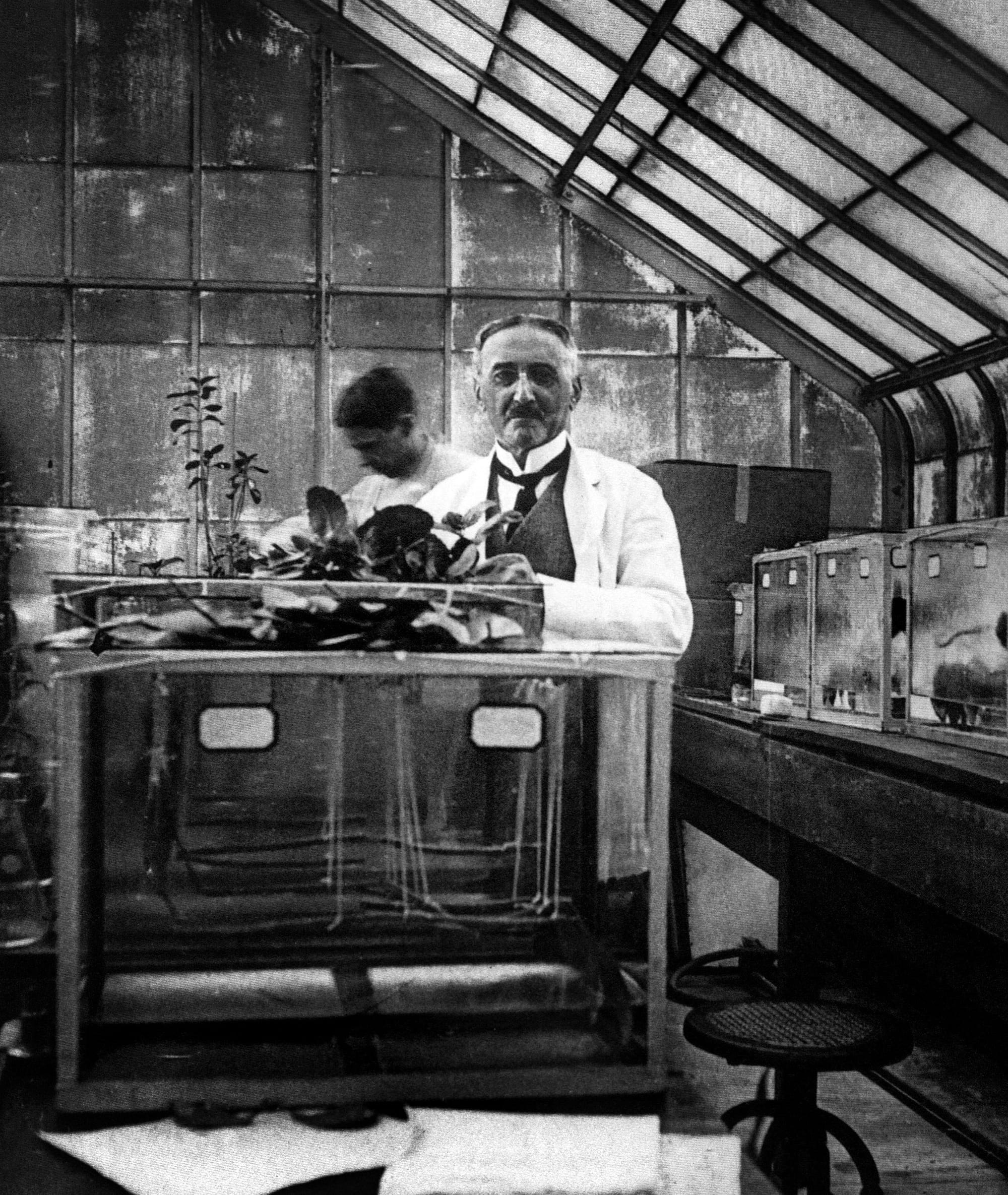 a black and white photograph of a man in a lab, slightly blurry with motion